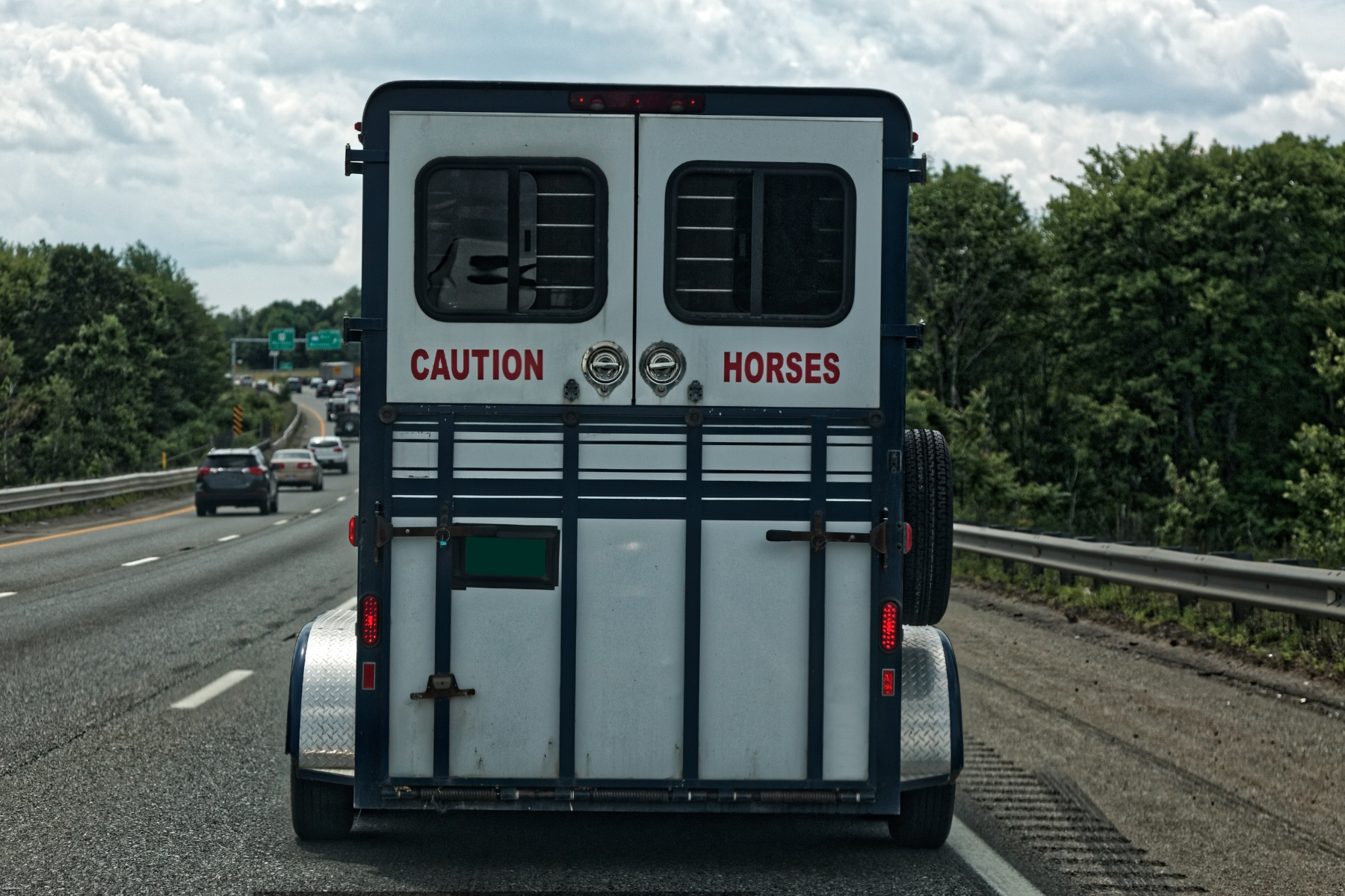 back of a horse trailer going down the road